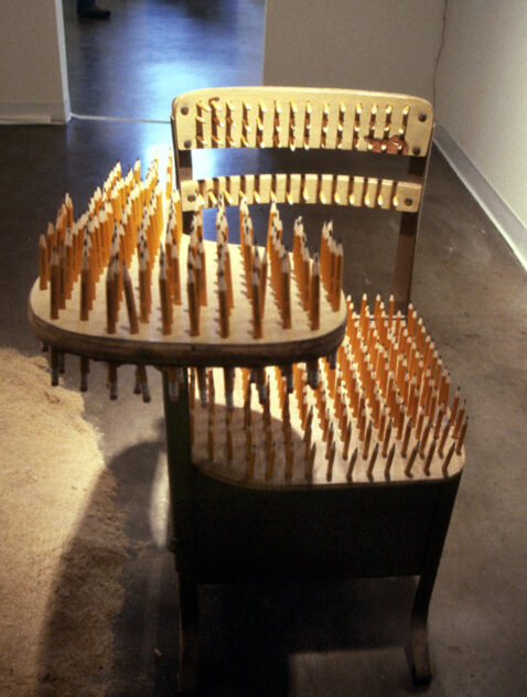 15,540 Miles, 2002 — artwork by artist Bradly Brown. School desk embedded with 444 upright No. 2 pencils